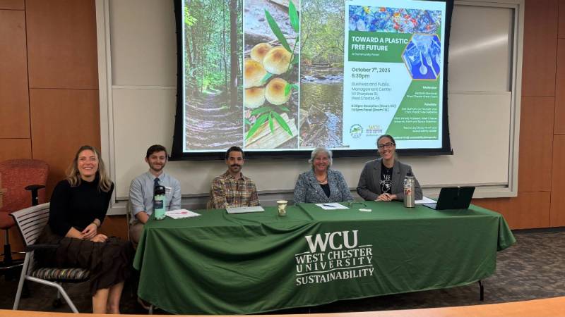 Panelists from the 2025 Panel on Plastics sit behind a table, smiling at the camera.