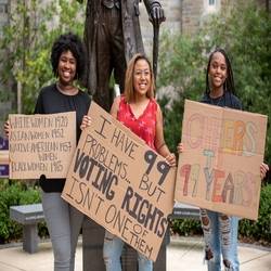 Picture of a group of individuals holding signs