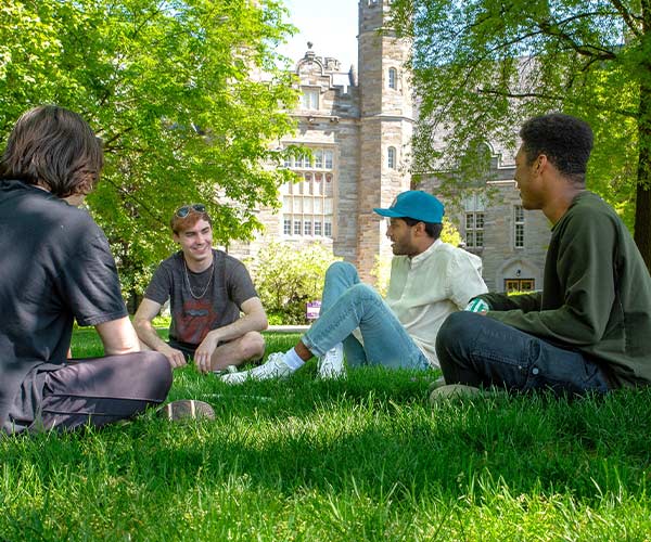 Students sitting in a circle in the grassy residential quad