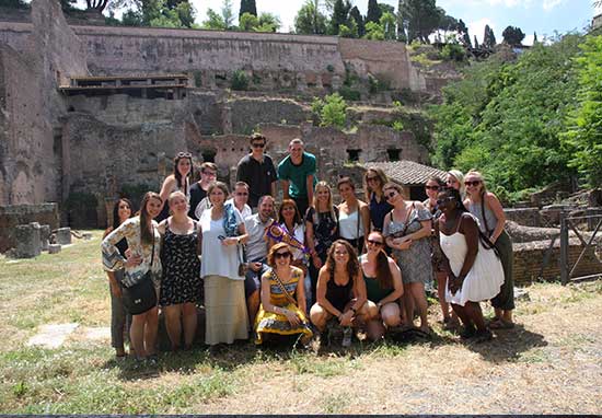 group posing in front of ancient building remains
