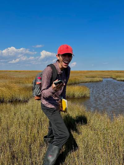Parker Edge an ESS alumni completing field work in a marsh.